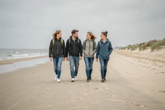 Famille se promenant sur la plage de La Panne avec les dunes en arrière-plan lors d'un week-end à la mer du Nord